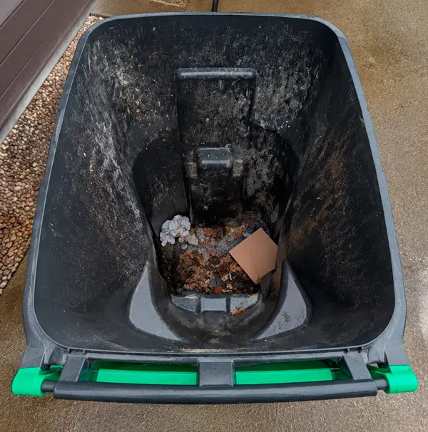 Dirty residential garbage bin with grime and food residue before cleaning in Grass Valley